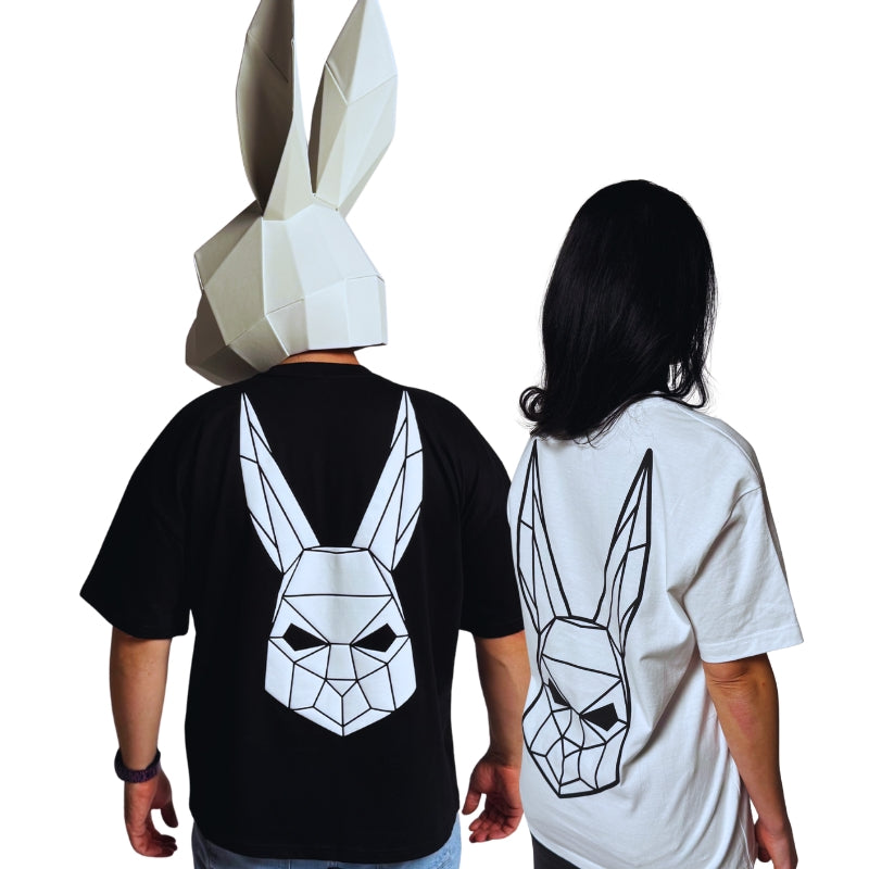 The Magician wearing a black t-shirt and the model wearing a white t shirt with The Magician's geometric rabbit mask on the back.